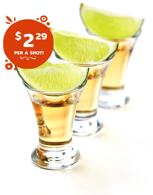 Three tequila shots garnished with lime wedges